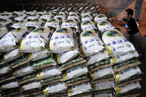8月19日,江西南昌县向塘镇金谷园粮食加工厂员工在搬运大米.